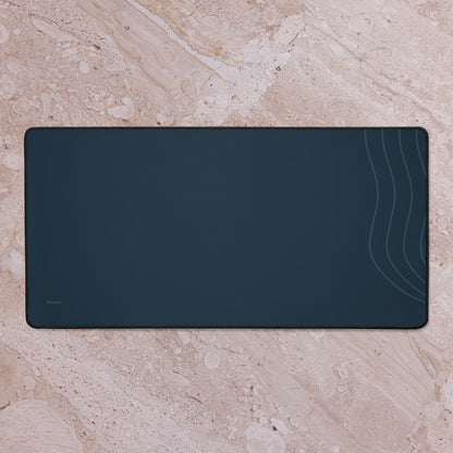 Digital mockup of the navy Sarnaya Contour Desk Mat on a pale stone surface, showing the curved lines along its right edge.