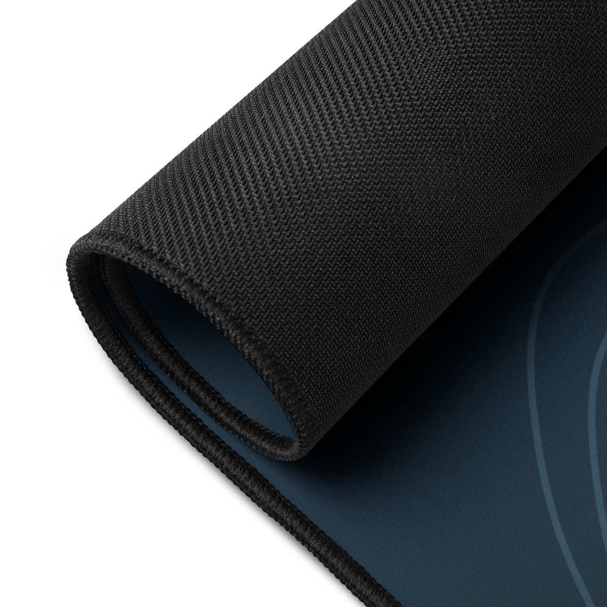 Digital mockup of the Sarnaya Contour Desk Mat with one corner rolled back, revealing the black textured underside and navy printed top.